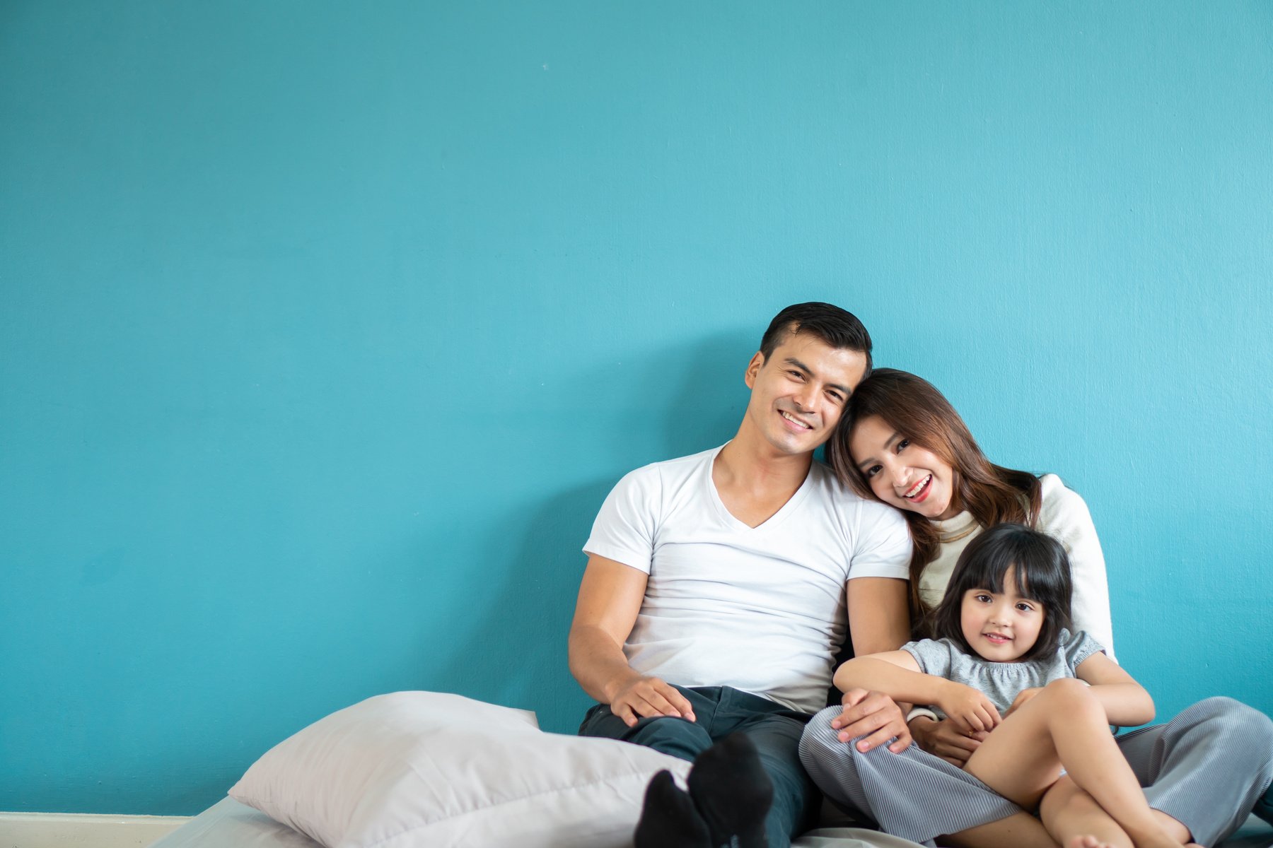 Portrait happy Asian family over blue background